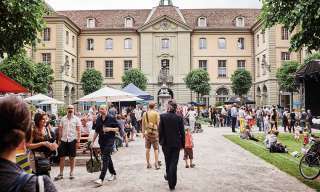 Im Innenhof vom Berner Generationenhaus findet ein Fest statt, es hat viele Besucherinnen und Besucher, diverse Essenstände und eine Musikbühne.