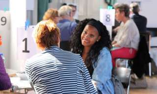 Menschen sitzen an Tischen und unterhalten sich.